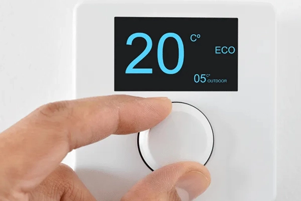Picture of a hand adjusting a thermostat